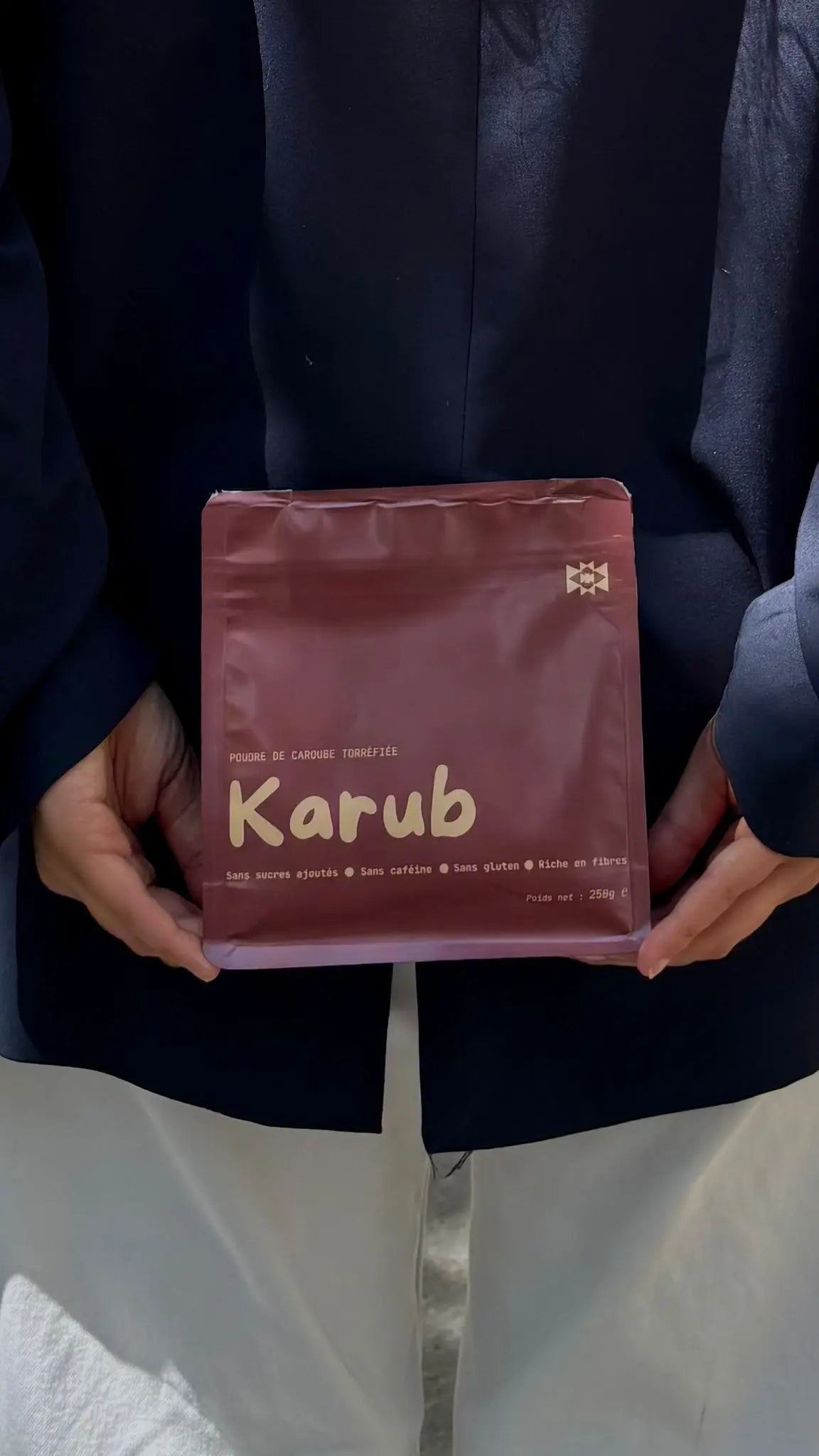une personne porte le sachet de caroube