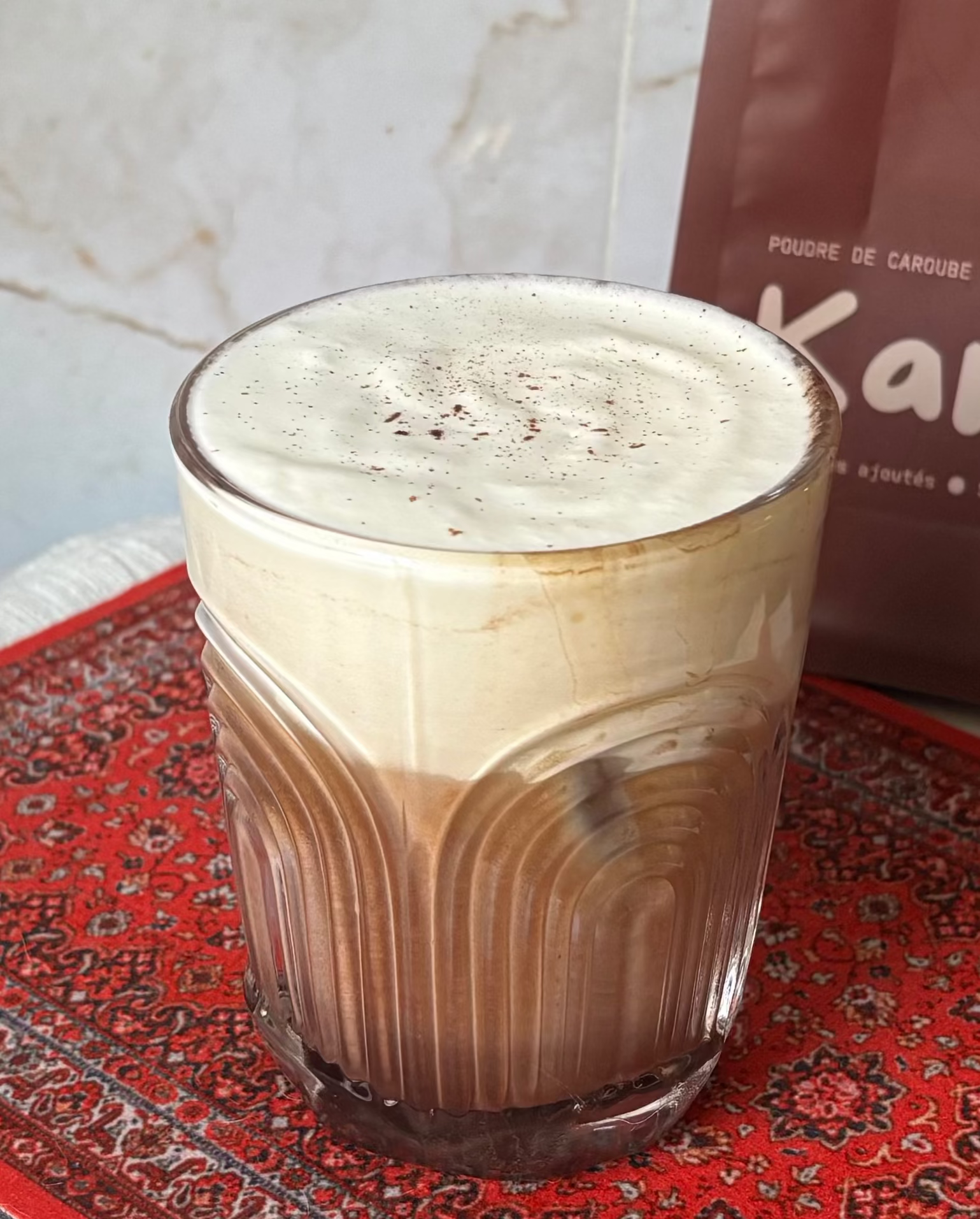 une tasse de latté caroube avec une creme